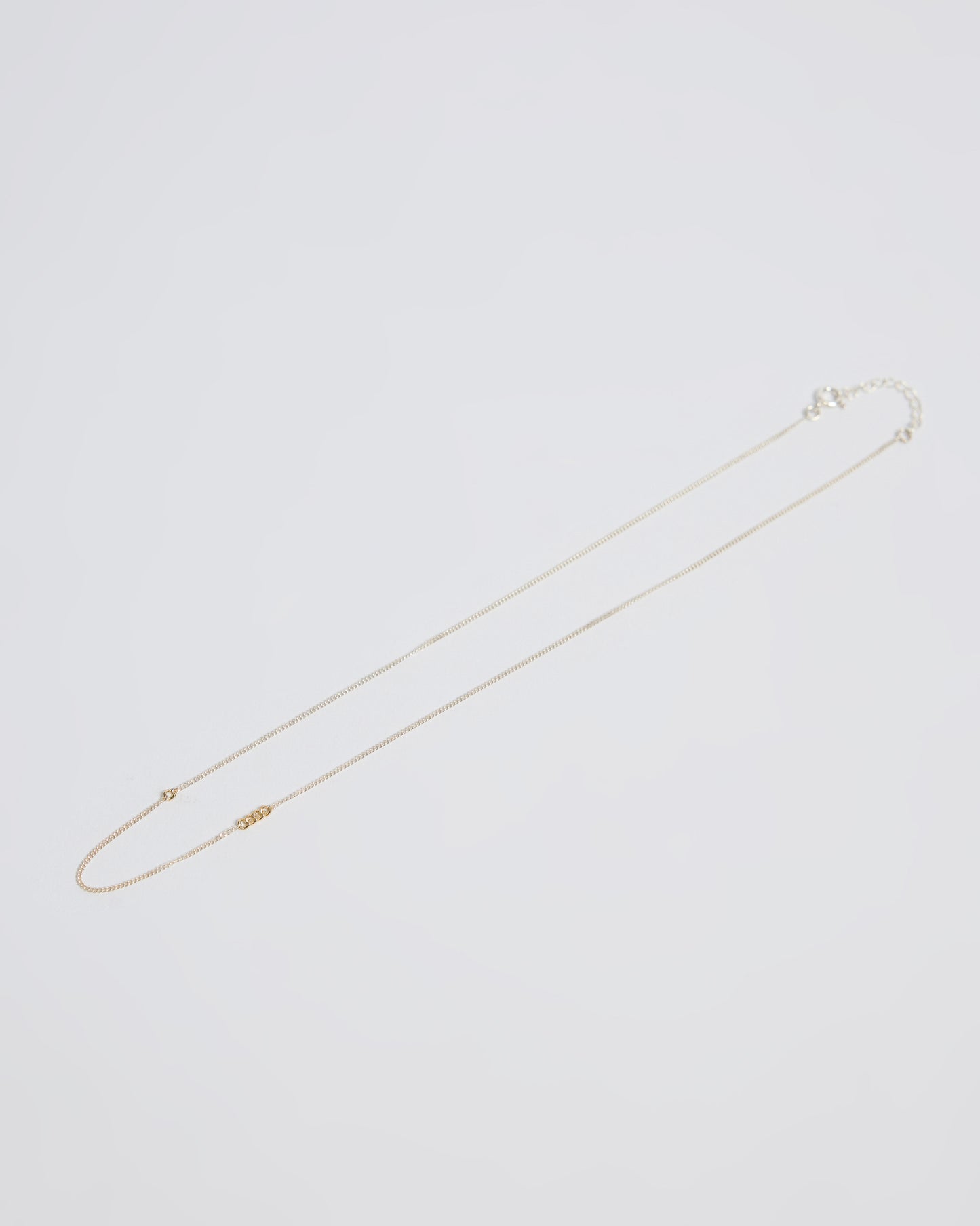 Floating product image of a sterling silver necklace with gold link accents