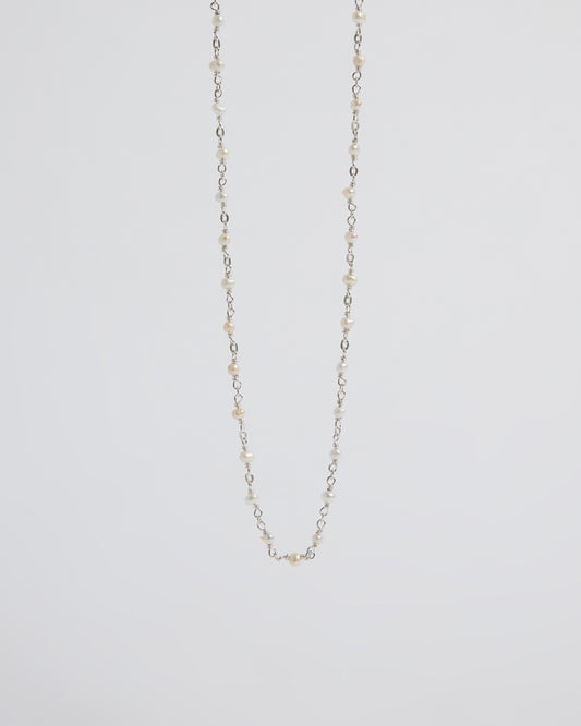 a super delicate pearl necklace that almost disappears into the skin