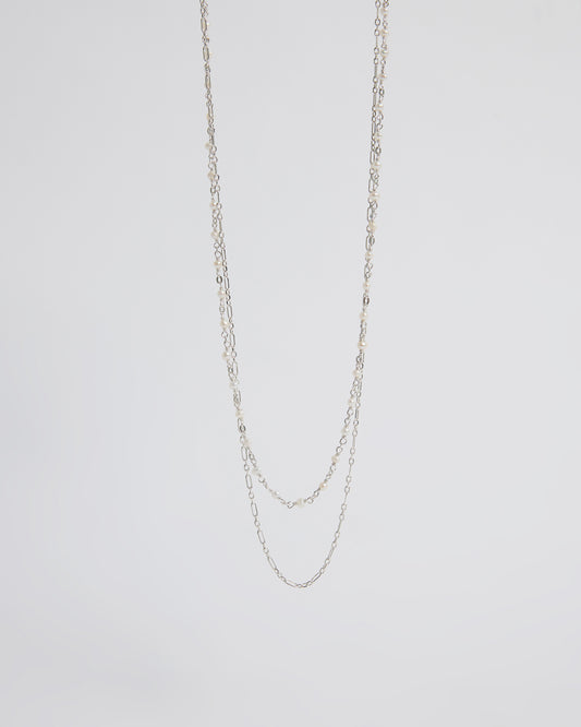 Silver chain necklace on a light gray background