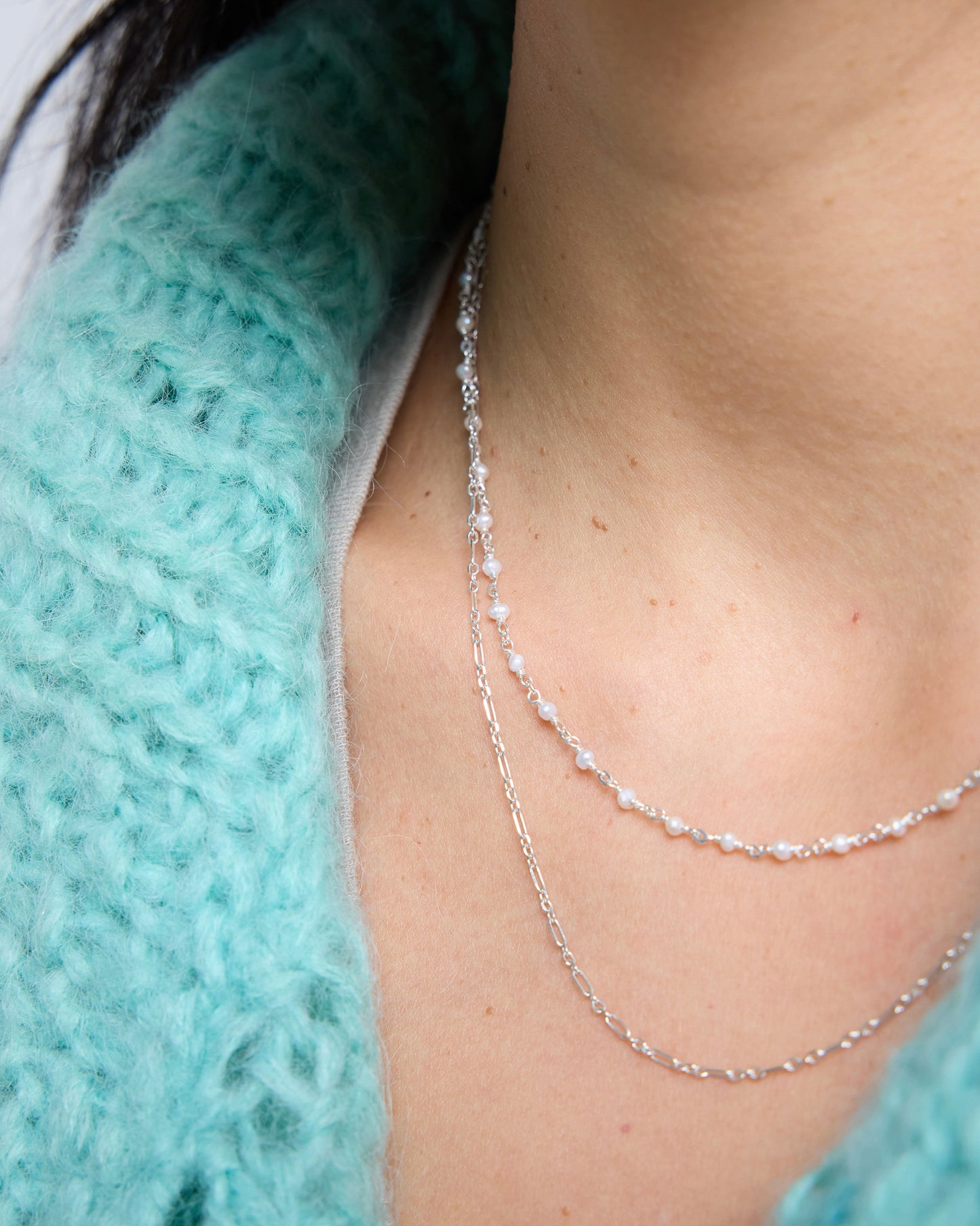 front view of a layered necklace combining pearls and a simple chain for a balanced look