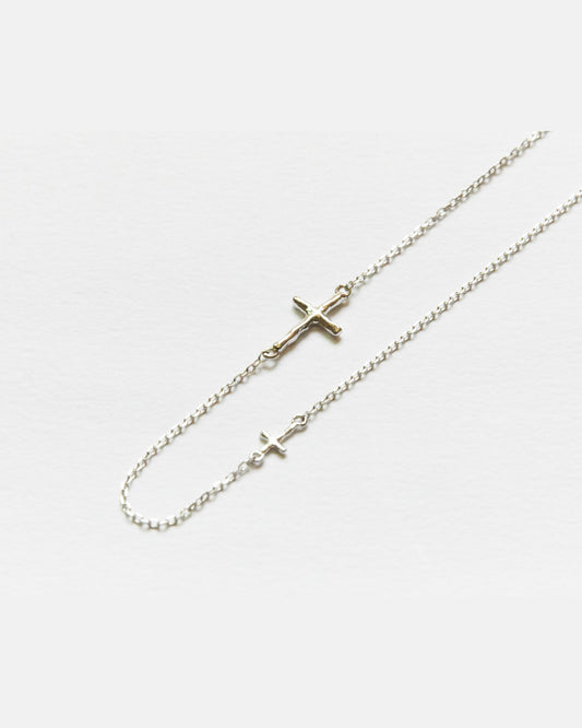 Close-up of two small silver crosses on a fine chain necklace – HANNA543 N314 twin cross chain