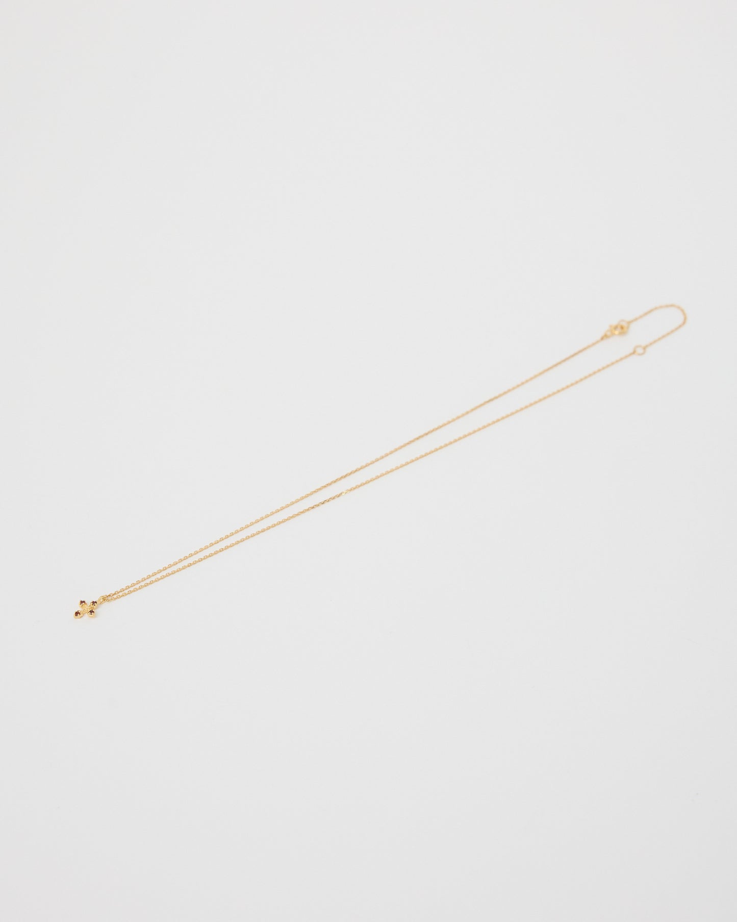 Gold necklace on a light gray background