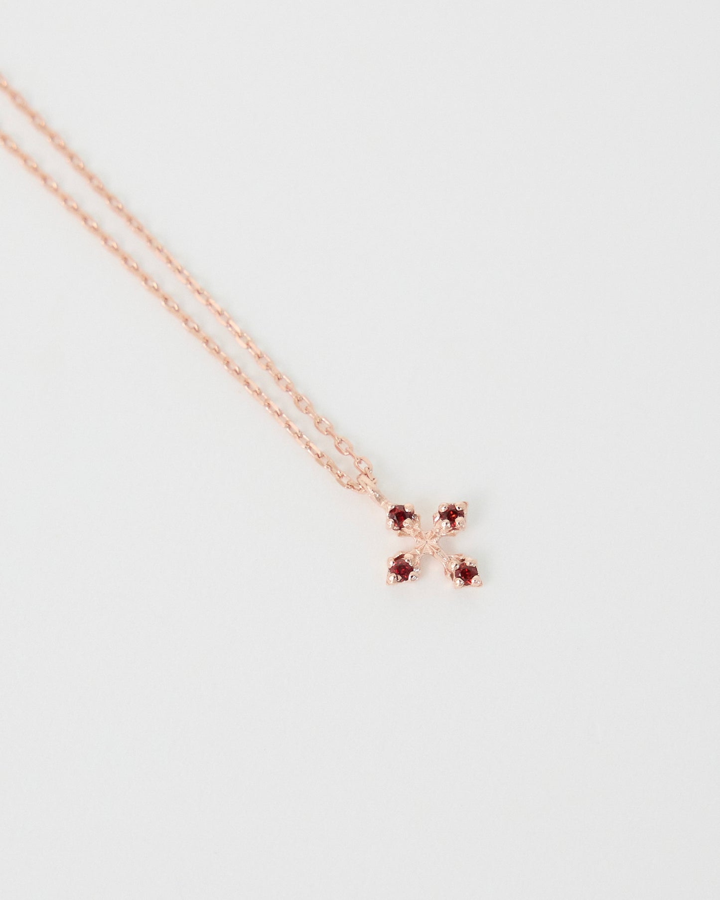Rose gold necklace with a star-shaped pendant on a light gray background
