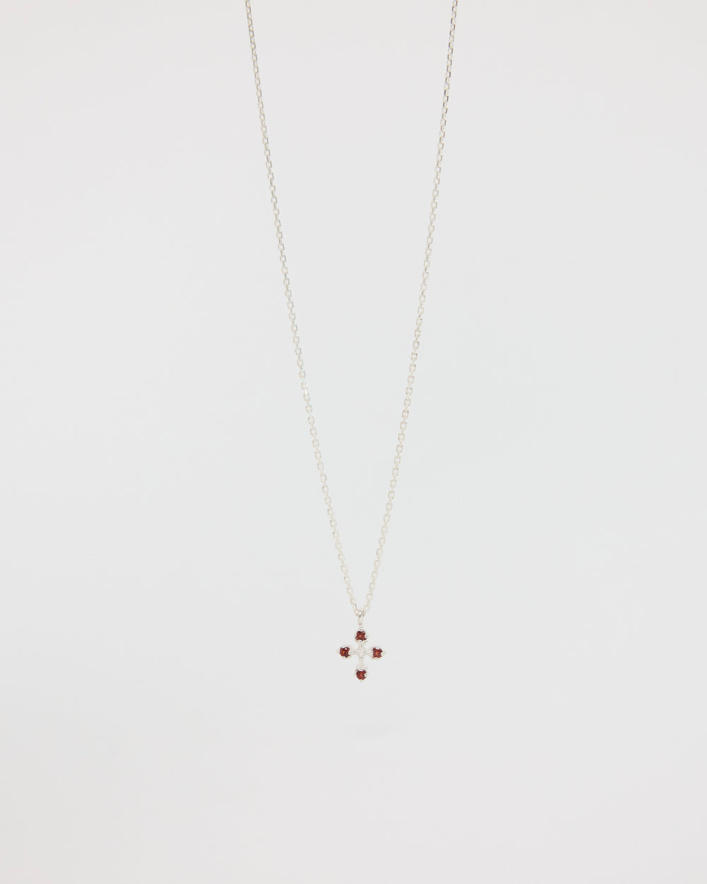 Necklace with a small cross pendant on a light gray background