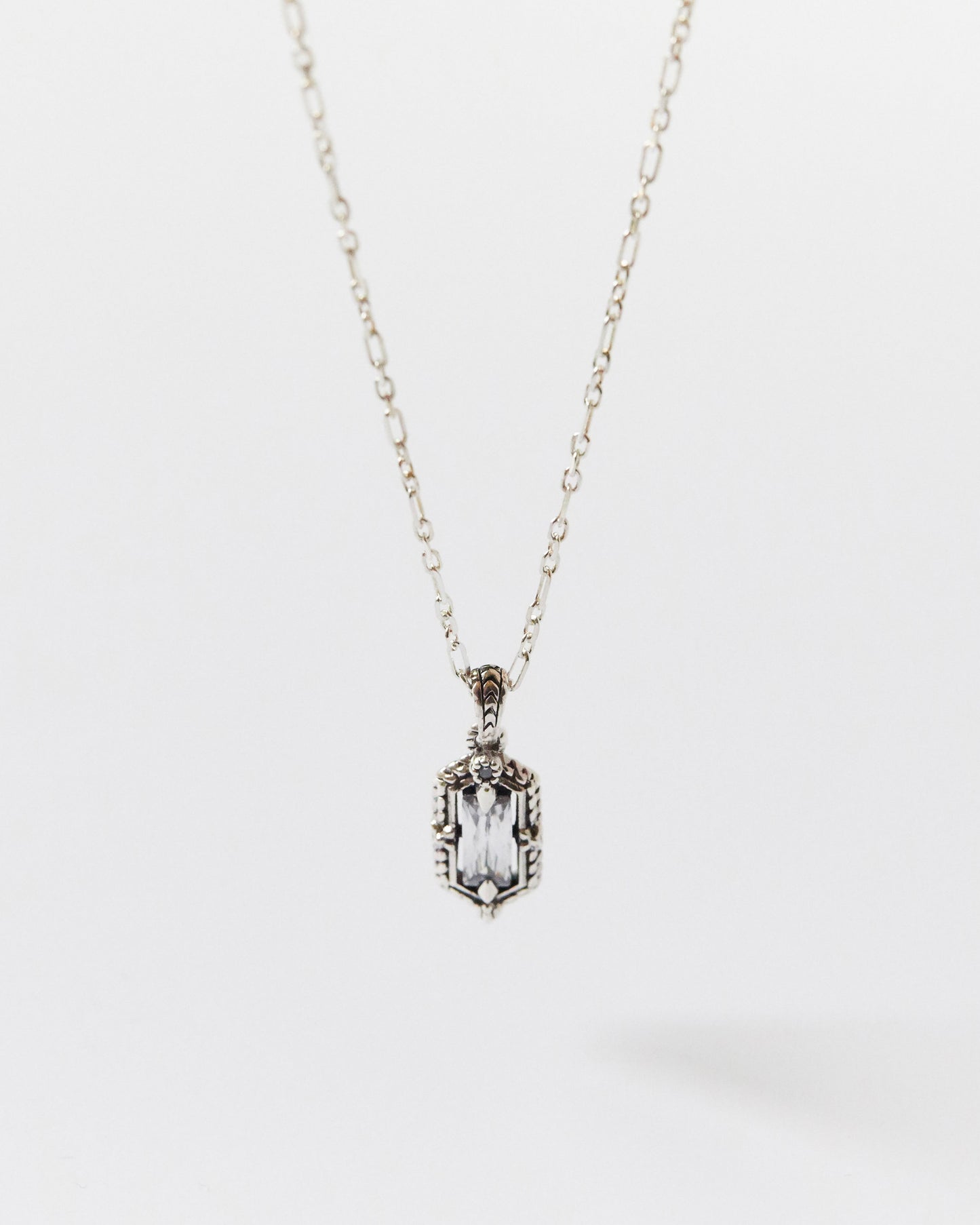 Silver necklace with a rectangular pendant on a white background
