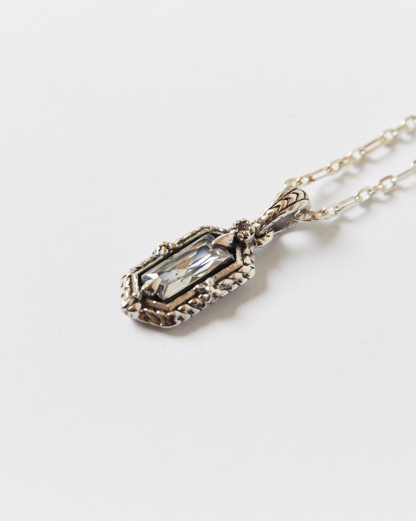 Silver necklace with a pendant on a light gray background