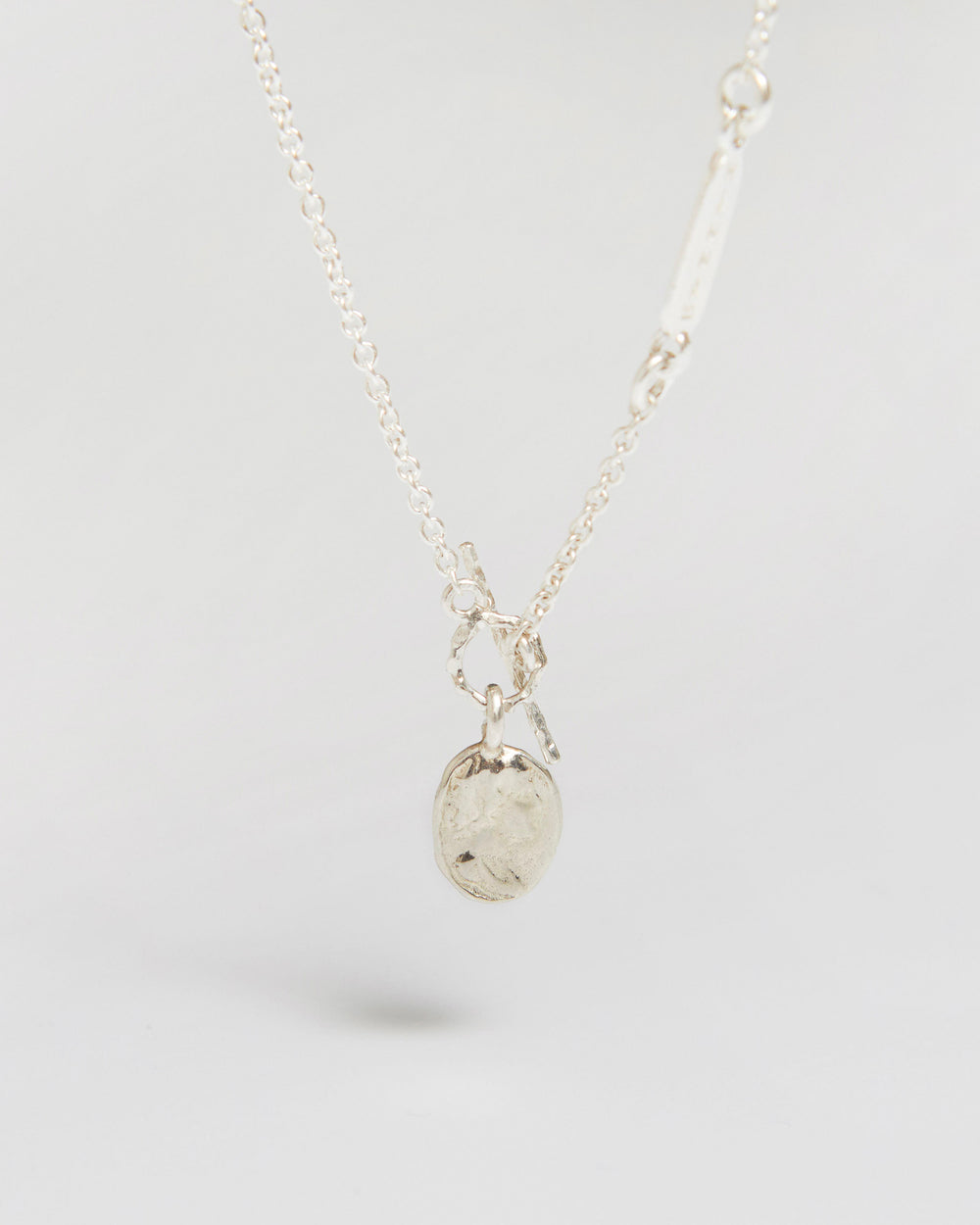 a delicate silver necklace with a tiny coin that feels way more important than it looks
