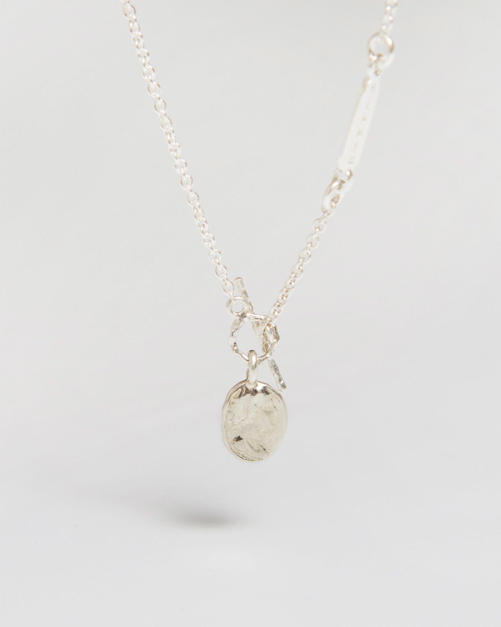 a delicate silver necklace with a tiny coin that feels way more important than it looks
