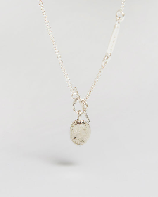 a delicate silver necklace with a tiny coin that feels way more important than it looks

