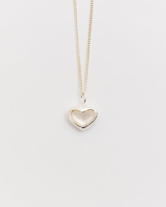 silver heart necklace with mother of pearl pendant on fine chain, minimal jewelry flat lay