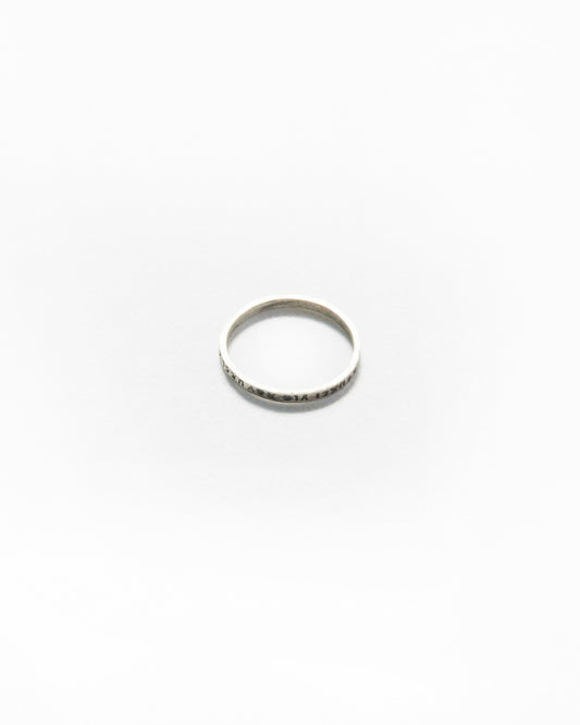 Top-view of slim engraved ring placed on white background, slightly oxidized finish for contrast