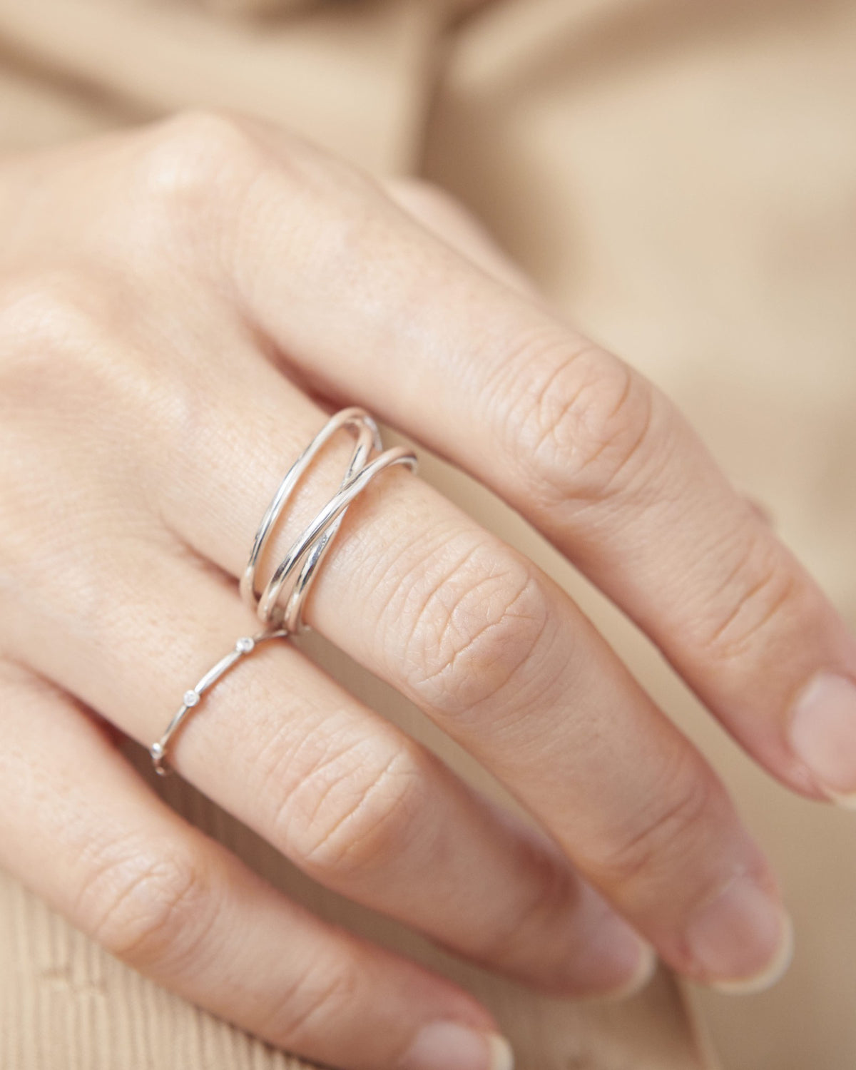 Hand wearing a silver triple line ring stacked with a dainty dot ring – HANNA543 R506 triple air lines