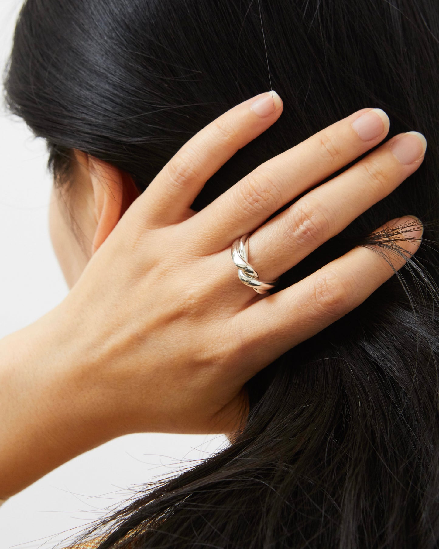 Close-up of a hand with a silver ring on a blurred background