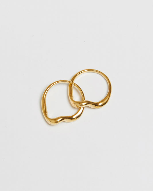 gold rings being held over an open palm, mid-air styling view